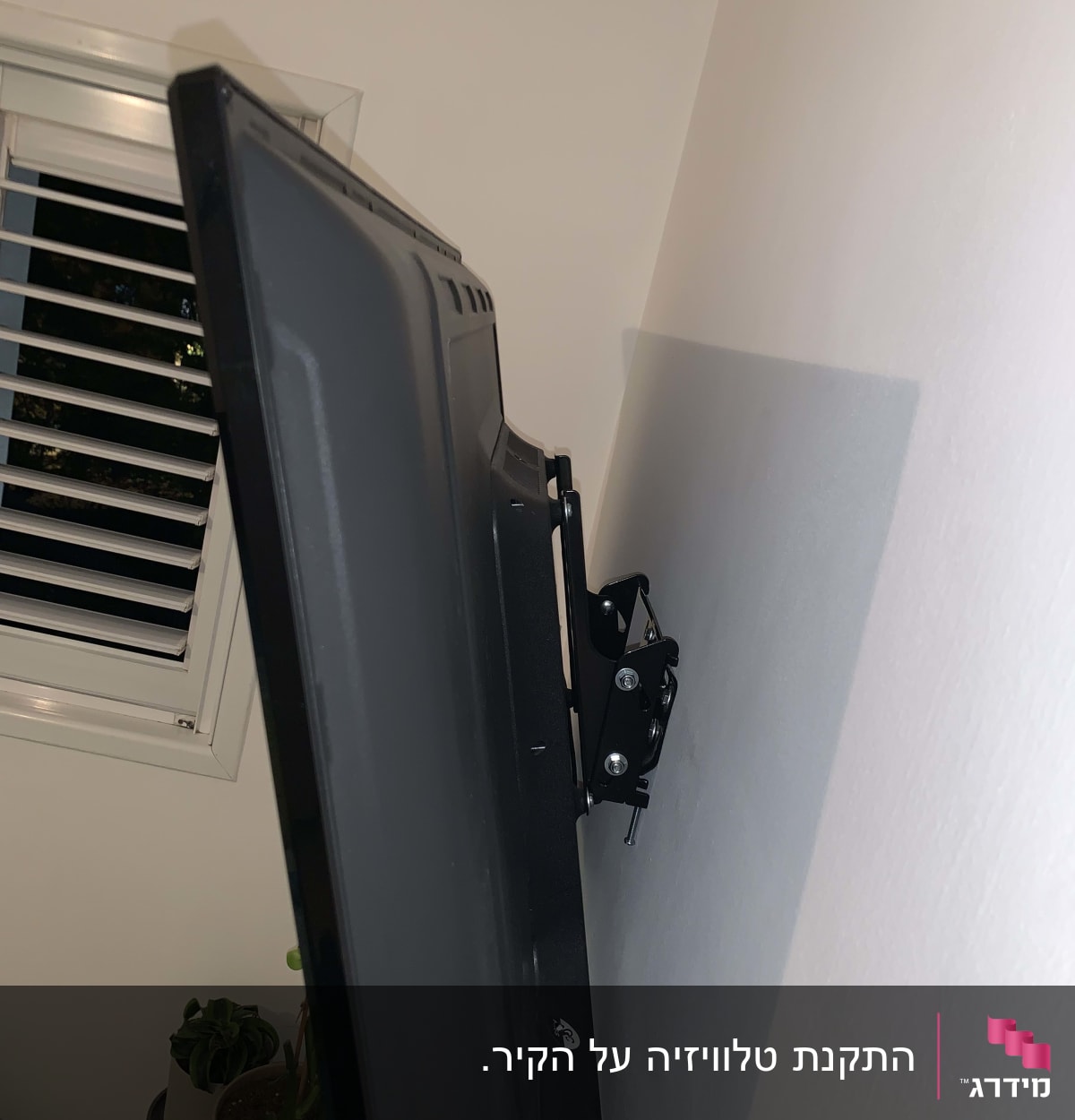 טלוויזיה מותקנת על קיר עם מתקן תלייה